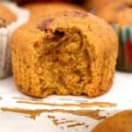 a chocolate chip pumpkin muffin with a bite taken out of it.