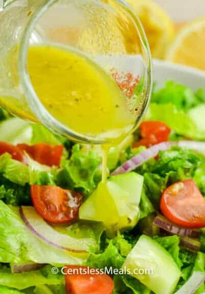close up of pouring Lemon Vinaigrette sauce on salad