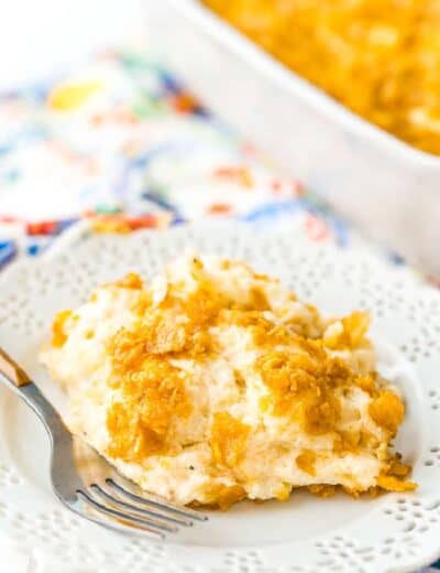Funeral potatoes on a white plate with a fork