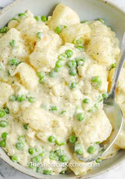 Creamy Potatoes and Peas in a bowl with a spoon