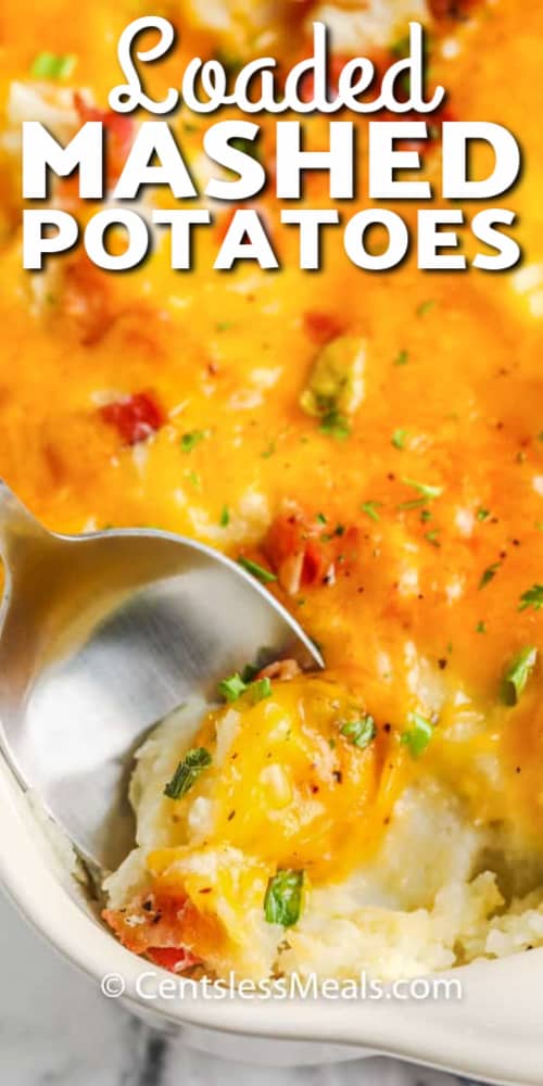 Loaded Mashed Potato Casserole with a serving being scooped up with a silver spoon, with a title.