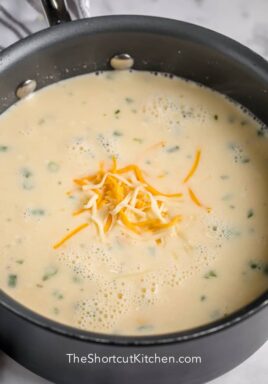 Creamy Potato Soup in a pot with shredded cheese on top