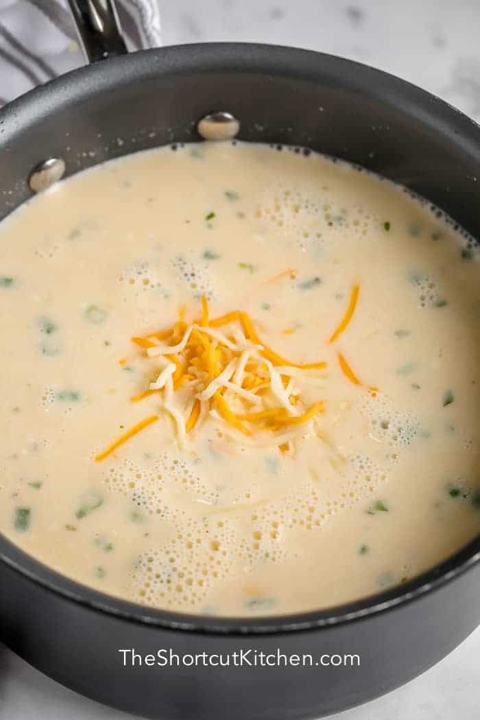 Creamy Potato Soup in a pot with shredded cheese on top