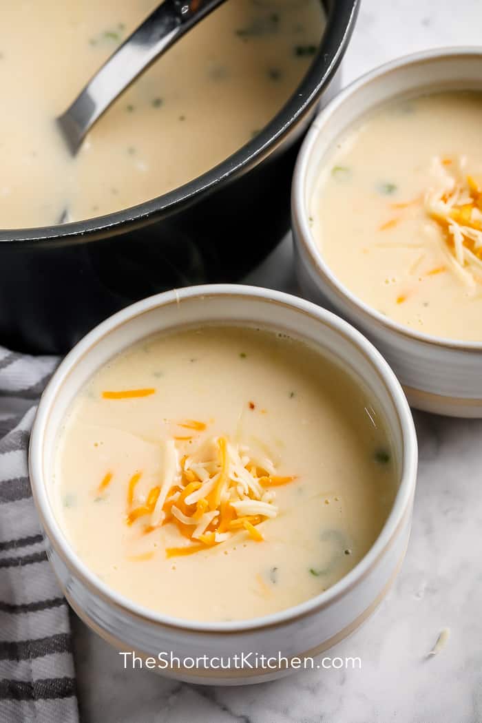 Creamy Potato Soup in two white bowls with the pot of soup on the side