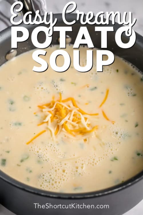 A pot of mashed potato soup garnished with shredded cheese, with a title.