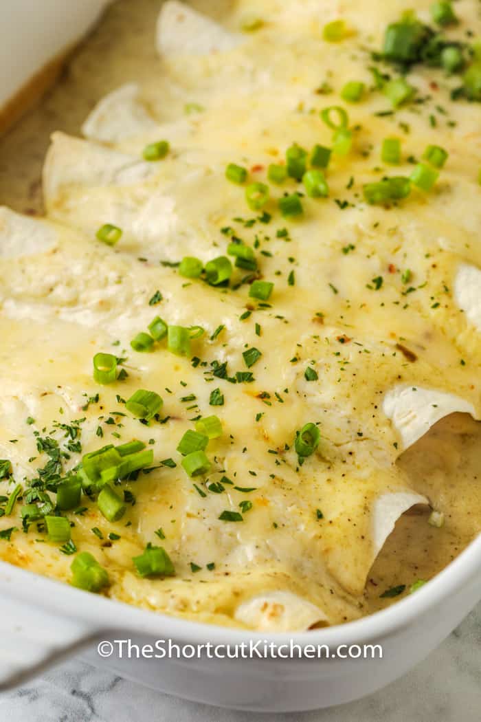 close up of cooked Sour Cream Chicken Enchiladas in the pan