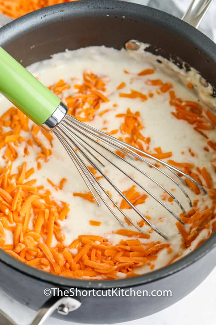 mixing cheese into pot to make Creamy Potato Soup