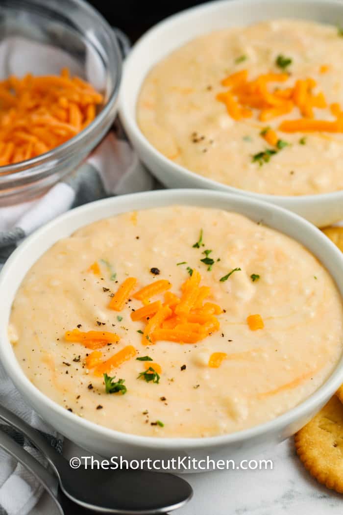 bowls of Creamy Potato Soup with a spoon and crackers beside it