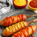 Air Fryer Frozen Corn Dogs on a plate with ketchup and mustard