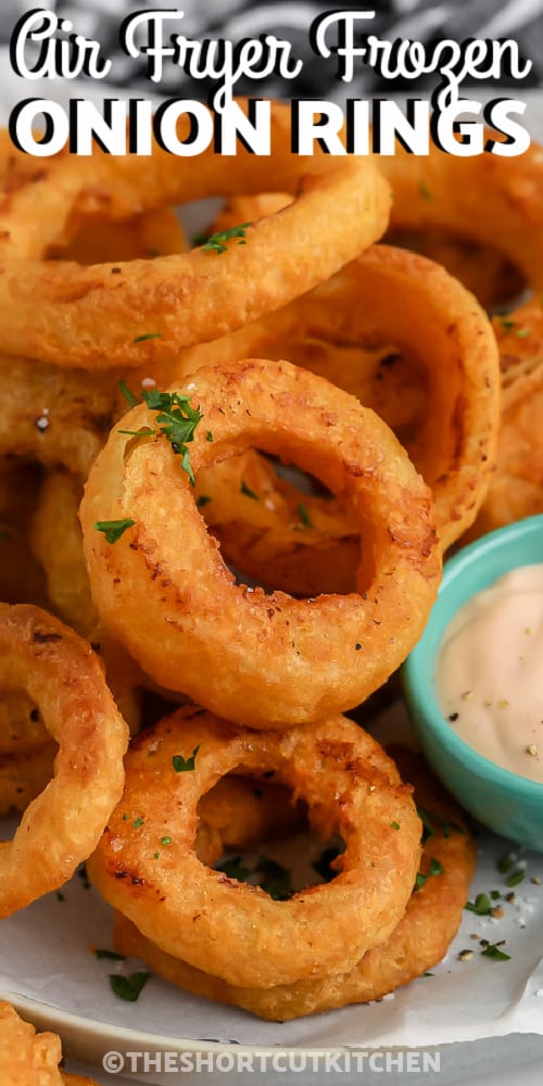 Air Fryer Frozen Onion Rings piled on a plate with dipping sauce on the side with a title