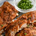 Instant Pot Ribs cut on a plate and garnished with parsley.