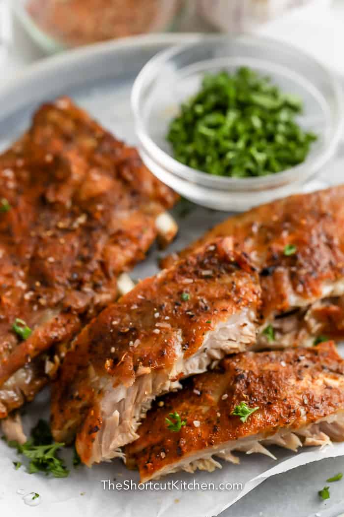 Instant Pot Ribs cut on a plate and garnished with parsley.