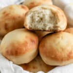 dinner rolls in a basket with a white cloth
