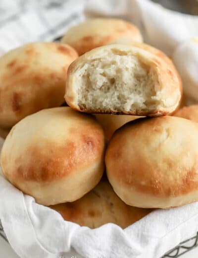 dinner rolls in a basket with a white cloth