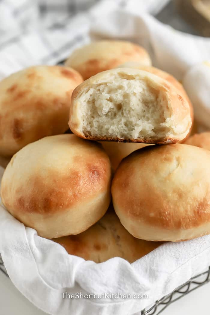 dinner rolls in a basket with a white cloth