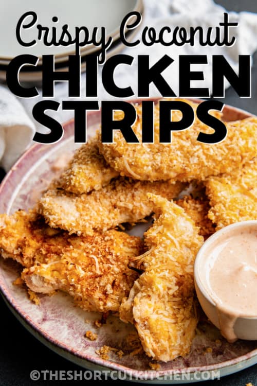 a plate of Crispy Coconut Chicken Strips with dipping sauce and text
