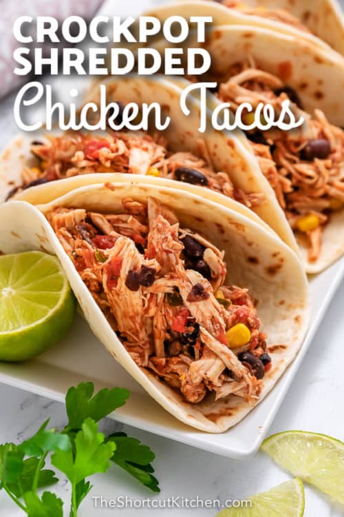 Crockpot shredded chicken tacos on a white plate with text