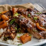 Sweet and spicy crock pot ribs plated with rice.