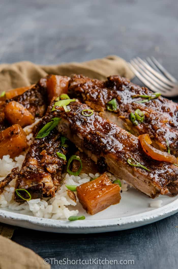 Sweet and spicy crock pot ribs plated with rice.