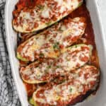 top view of lasagna stuffed zucchini boats in a white dish