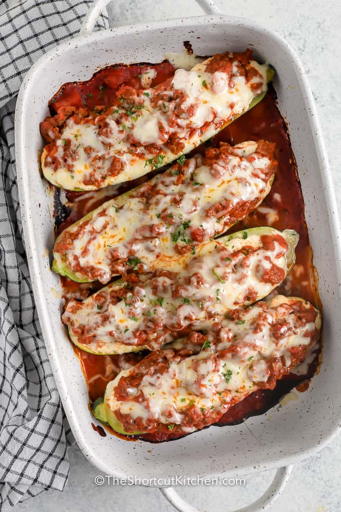 top view of lasagna stuffed zucchini boats in a white dish