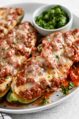 lasagna stuffed zucchini boats on a white plate