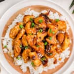 Sweet & Sour Chicken in a bowl with rice and green onions