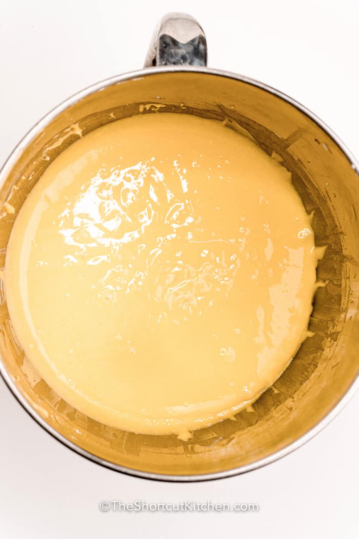 Chocolate chip bundt cake is perfect when you want a homemade dessert without the stress. The batter mixes up fast and bakes into a tall, golden cake filled with pockets of melted chocolate. Sour cream keeps the cake rich while vanilla adds classic flavor everyone loves. Serve it plain for everyday treats or dress it up for special occasions and celebrations with friends and family. #theshortcutkitchen Chocolate Chip Bundt Cake batter in a mixing dish