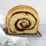 a loaf of baked Cinnamon Swirl Bread with a slice missing