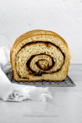 a loaf of baked Cinnamon Swirl Bread with a slice missing