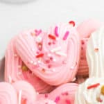 close up of pink and white Heart Meringues with sprinkles