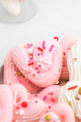 close up of pink and white Heart Meringues with sprinkles