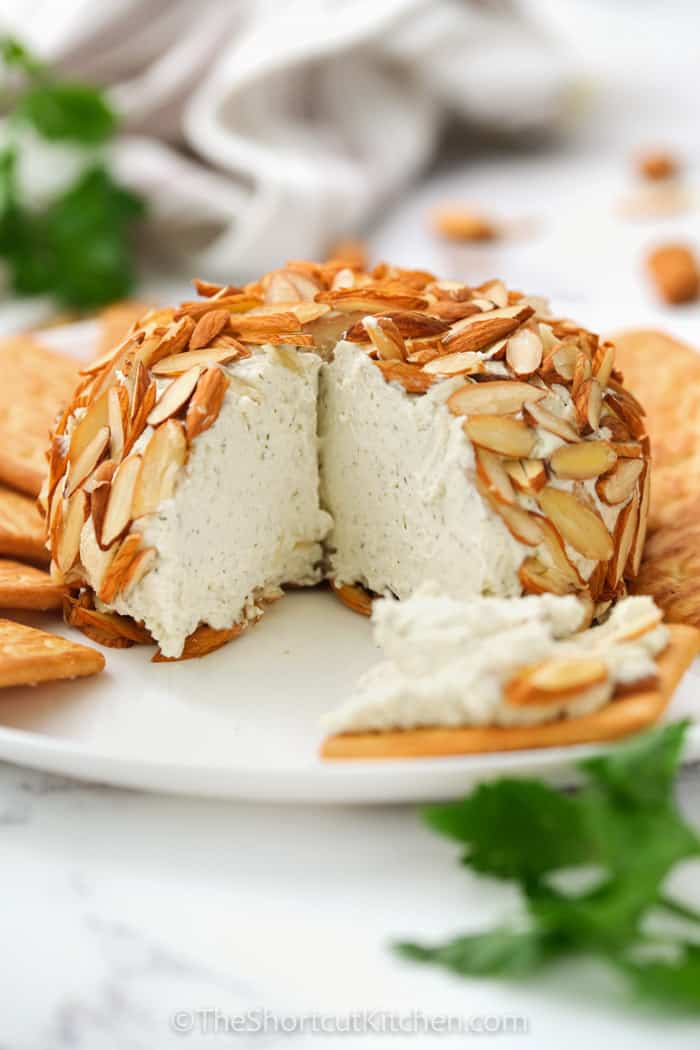 Parmesan Ranch Cheeseball with a slice taken out and crackers