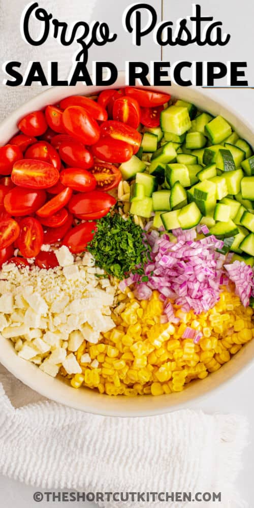 ingredients in a bowl to make an Orzo Pasta Salad with a title