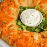 Baked Buffalo Chicken Ring with dip in the center.