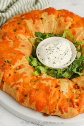 Baked Buffalo Chicken Ring with dip in the center.