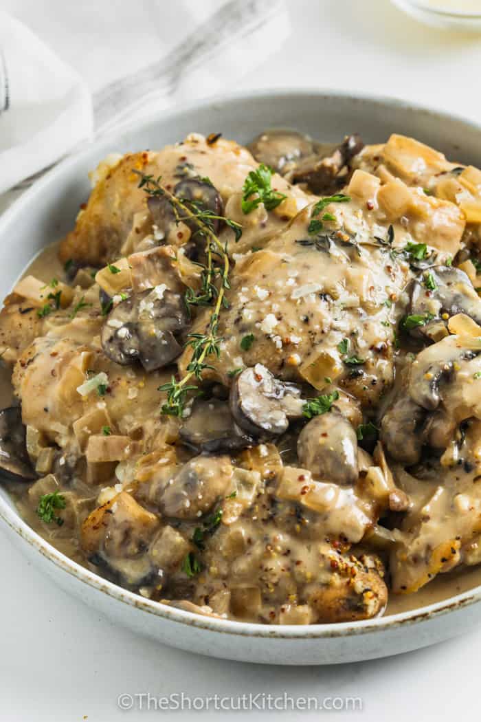 a serving dish of creamy crockpot chicken thighs with mushrooms