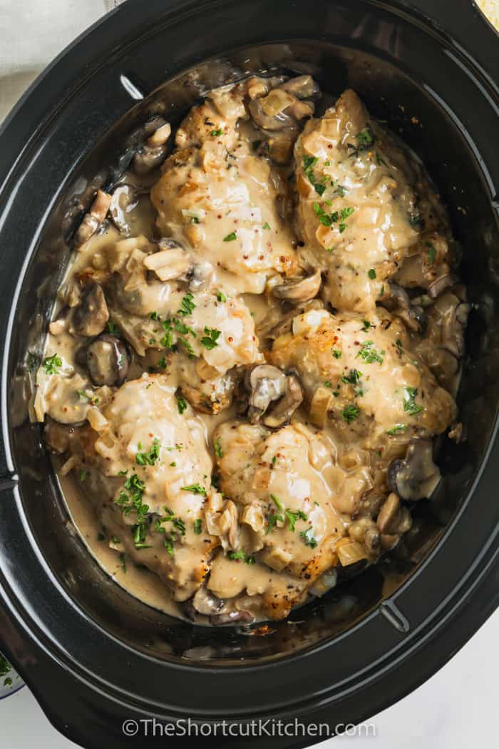 creamy crockpot chicken thighs with mushrooms in a slow cooker