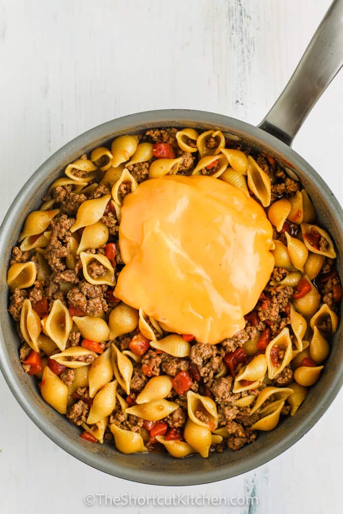 Cheesy Ground Beef Pasta in a pot with cheese sauce on top.