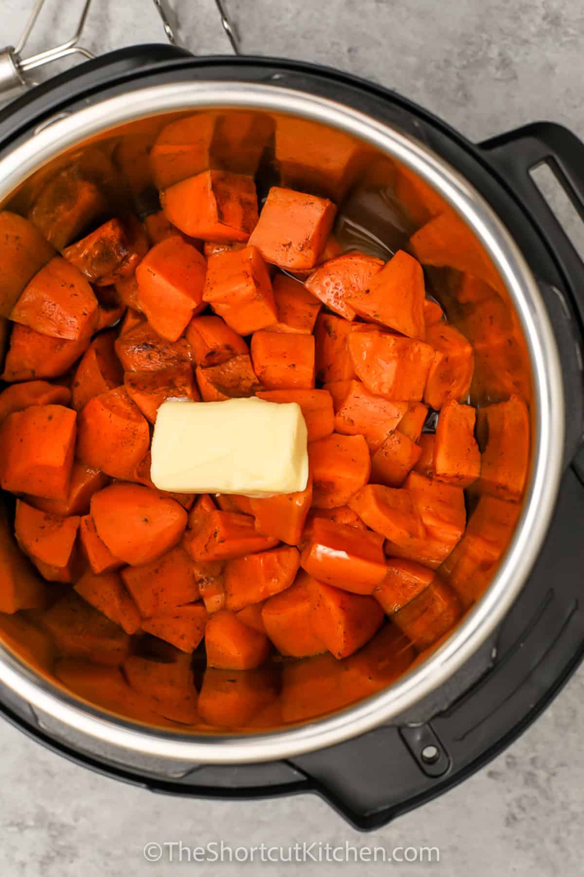 adding butter to pot to make Instant Pot Mashed Sweet Potatoes