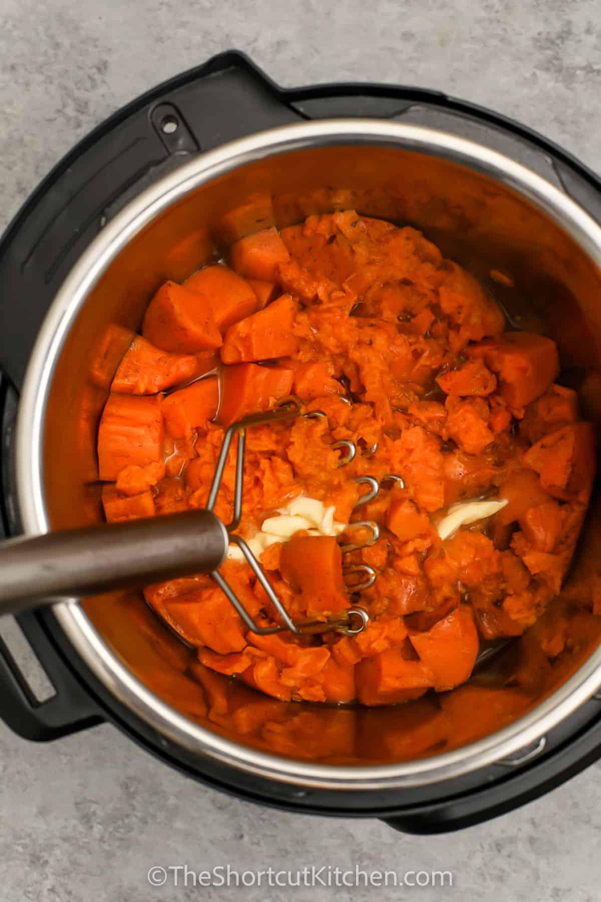 mashing ingredients together to make Instant Pot Mashed Sweet Potatoes