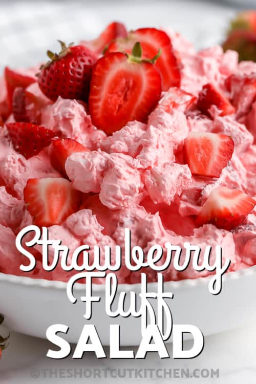 A serving dish of Strawberry Fluff salad topped with strawberry chunks with writing