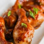 A close up of a plate of soy sauce chicken drumsticks