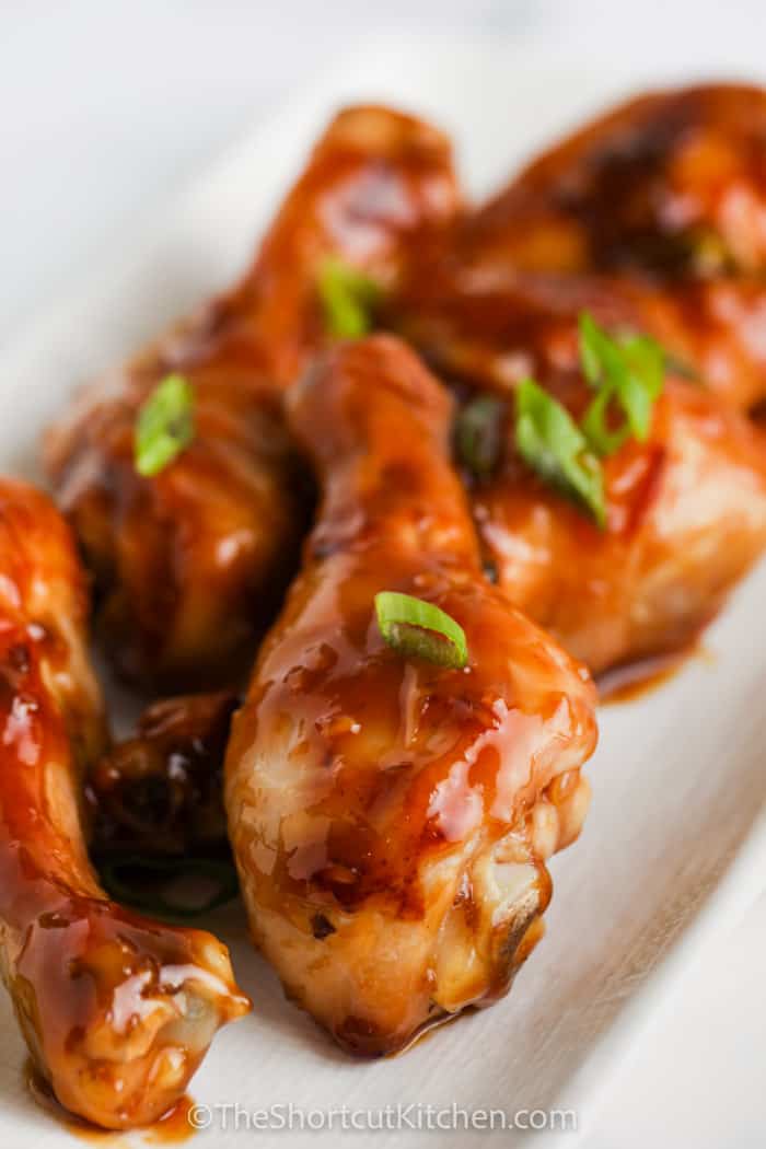 A close up of a plate of soy sauce chicken drumsticks