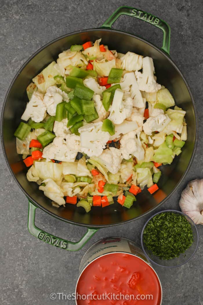 adding vegetables to pot to make Vegetable Soup With Cabbage