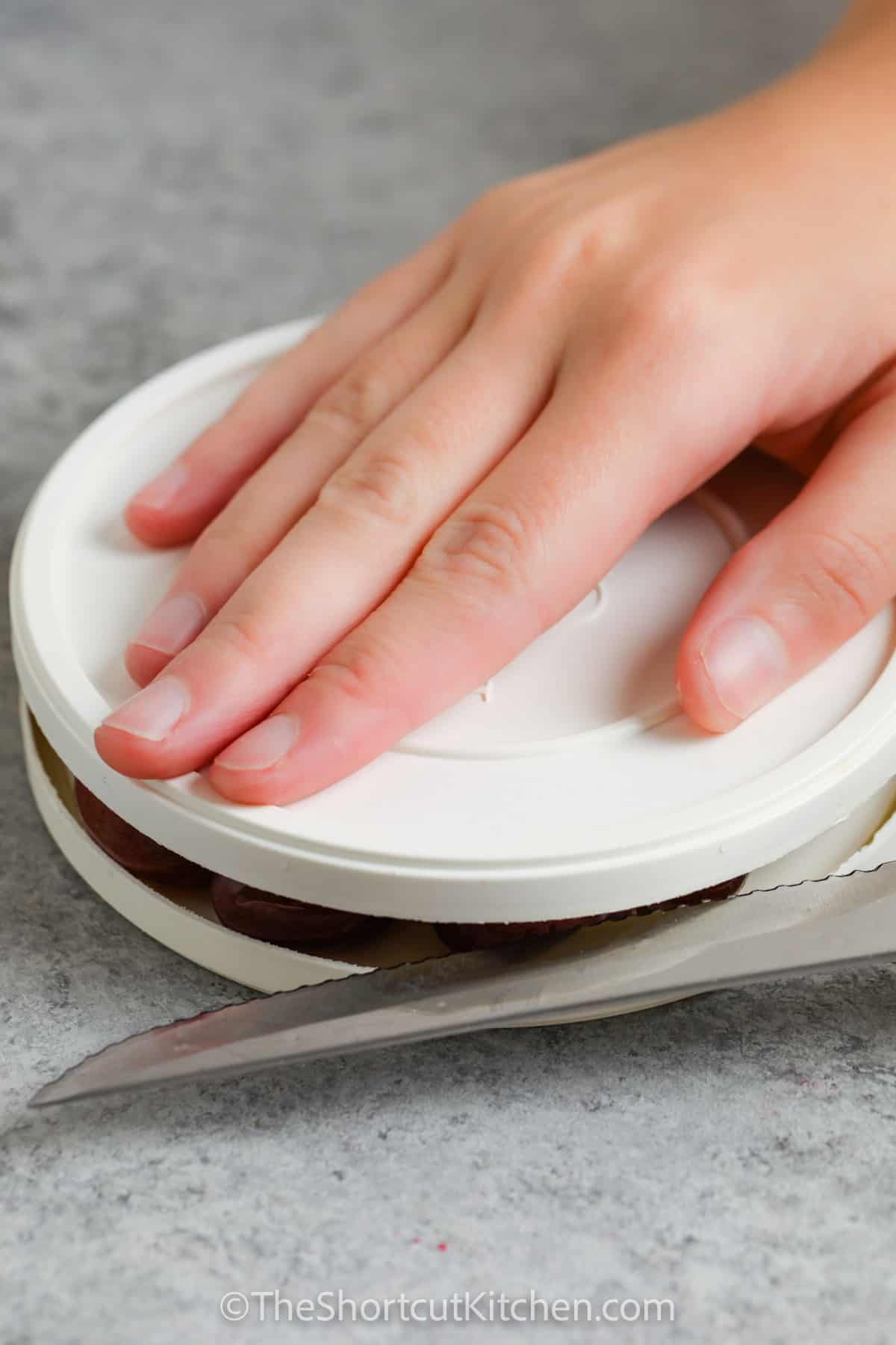 This recipe for grape salad is a creamy, chilled dish made with tangy sour cream, fluffy cream cheese, sweet brown sugar, and halved grapes. After chilling, it’s topped with crunchy pecans and more sugar if desired. Perfect as a potluck favorite or an easy dessert, it offers a balance of texture and taste. It’s rich, refreshing, and surprisingly simple to whip up in minutes. #theshortcutkitchen cutting grapes to make an Easy Grape Salad