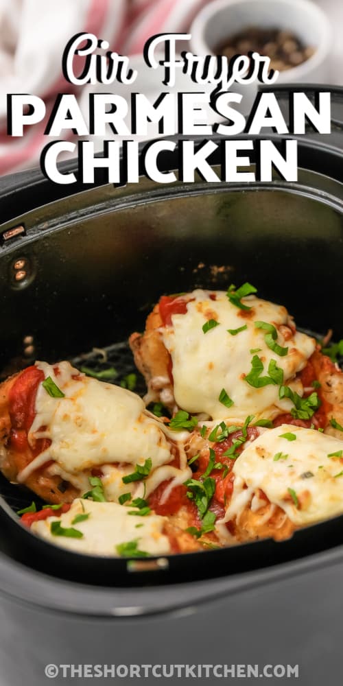 Cooked Parmesan Chicken in an air fryer basket with writing