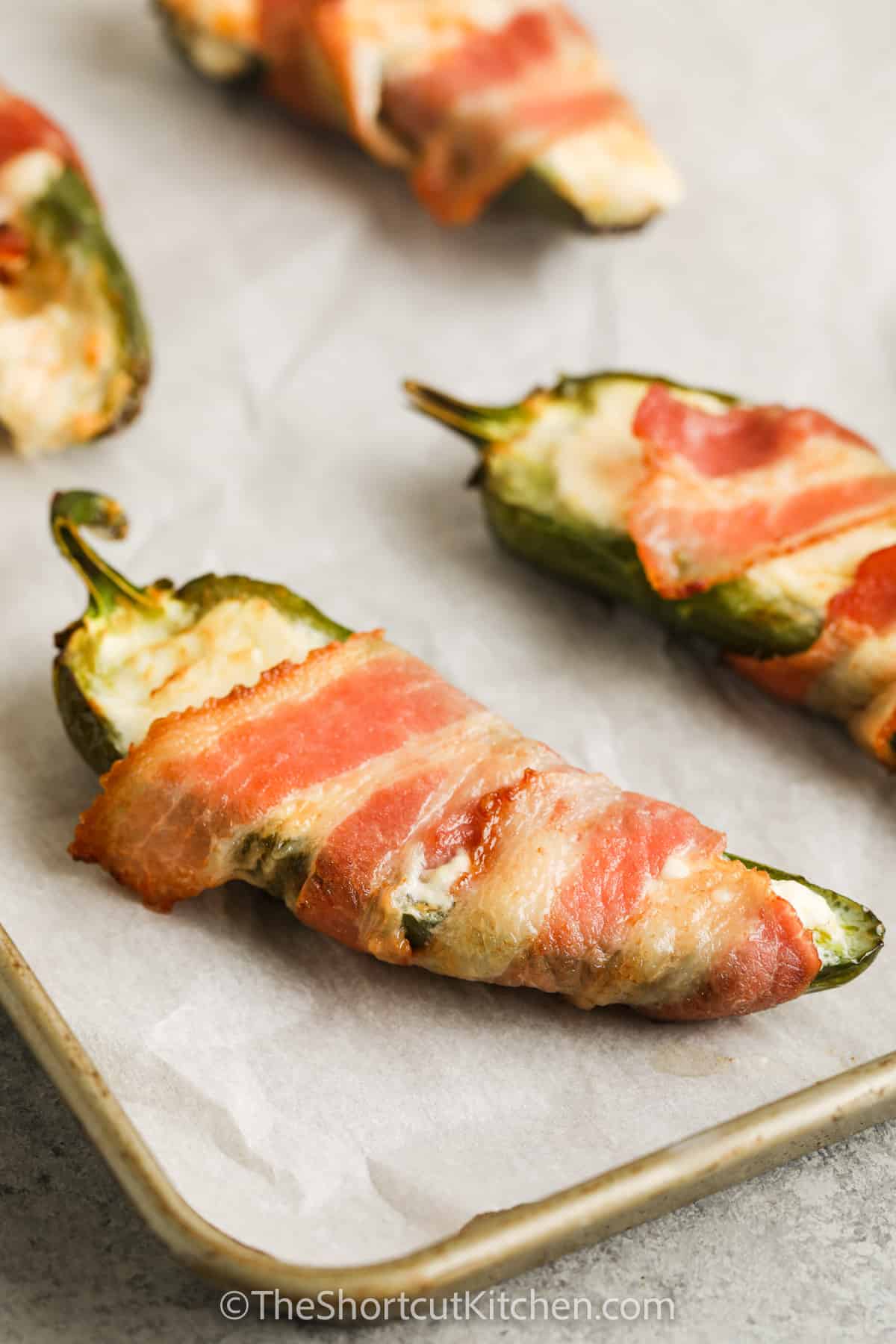 Bacon Wrapped Stuffed Jalapenos on a baking sheet