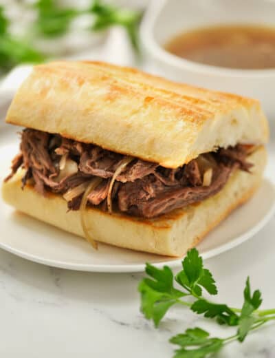 plated Crock Pot French Dip Recipe with dip in the back