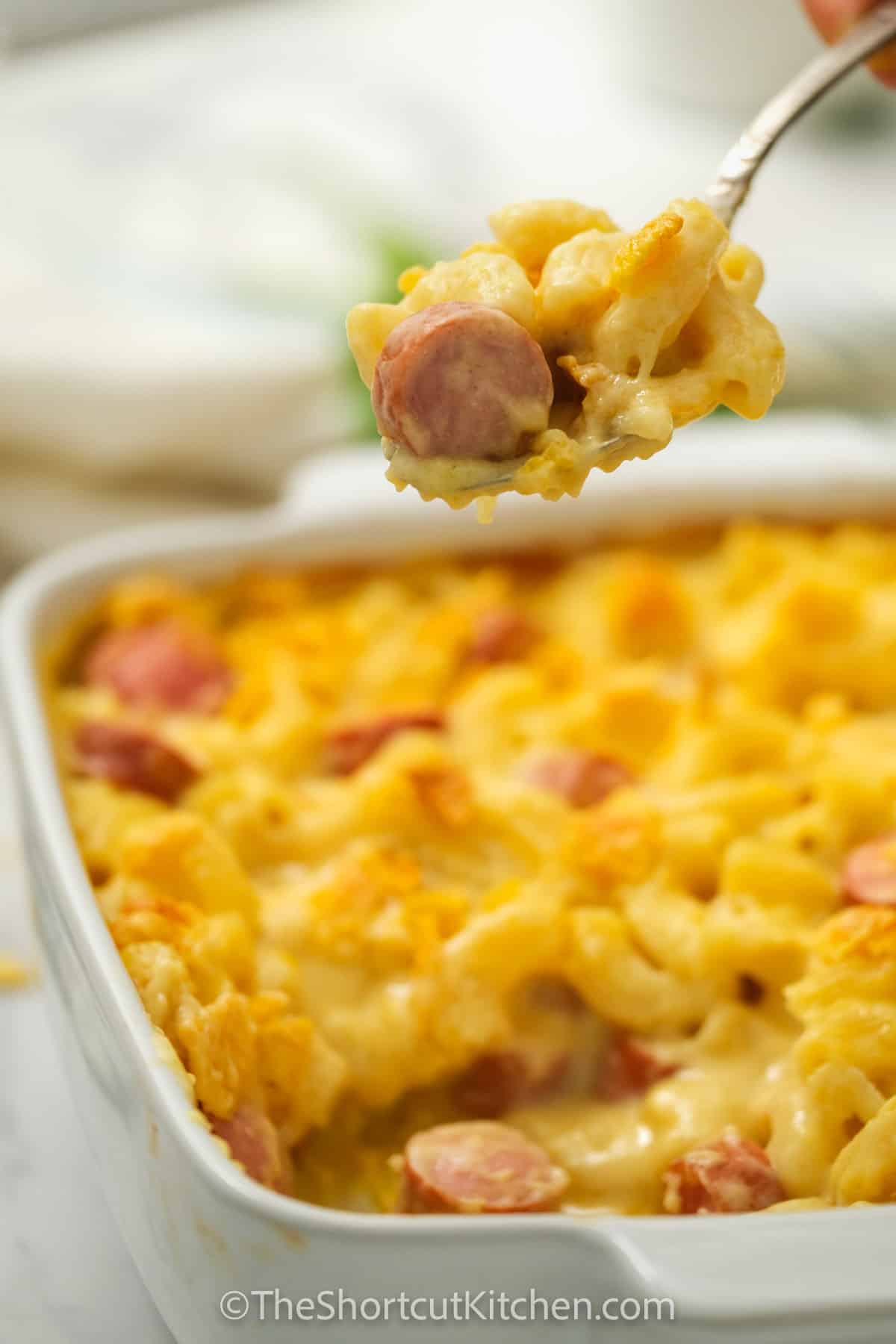 Mac and Cheese Hot Dog Casserole with some on a spoon